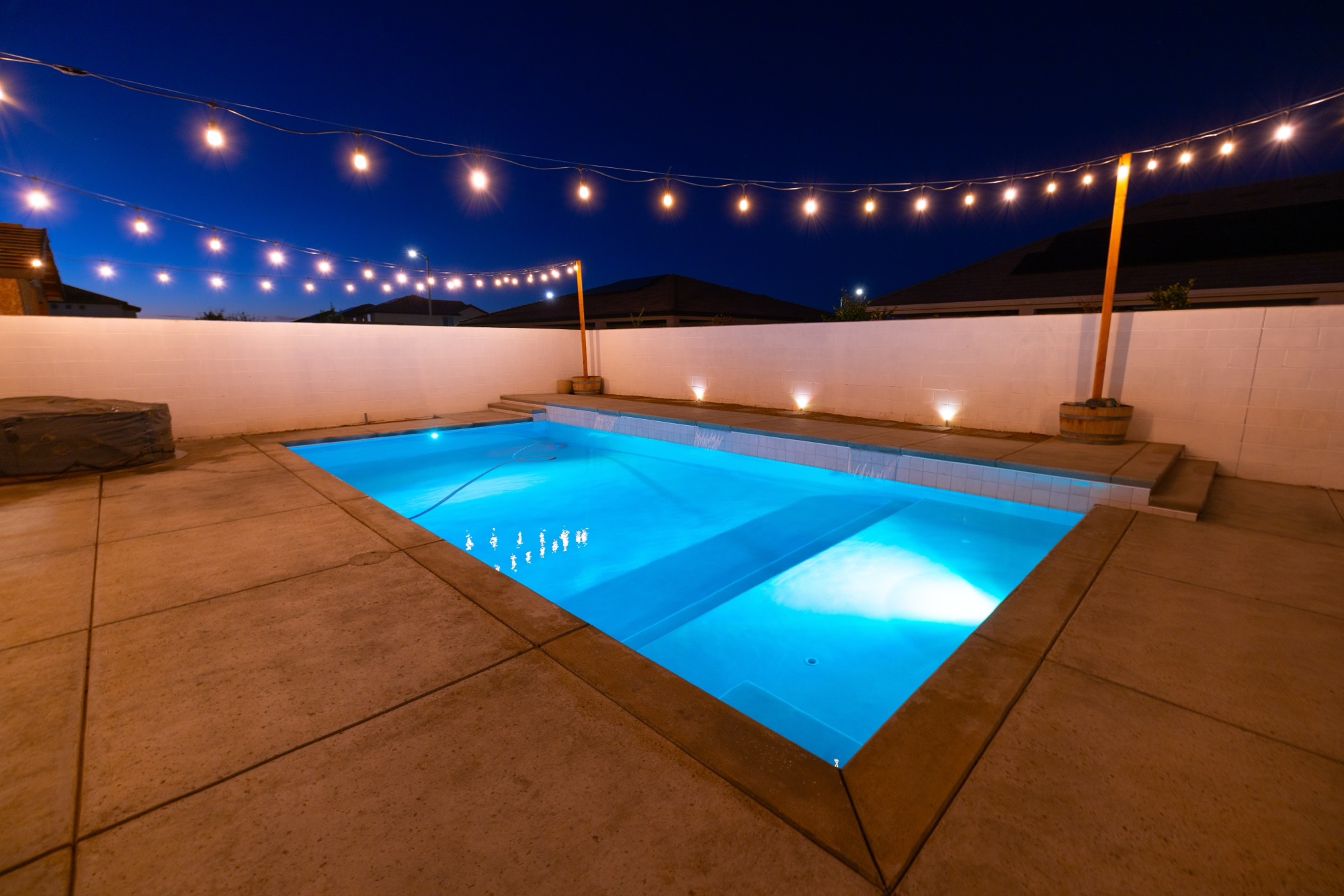 Custom gunite pool at night with string lights