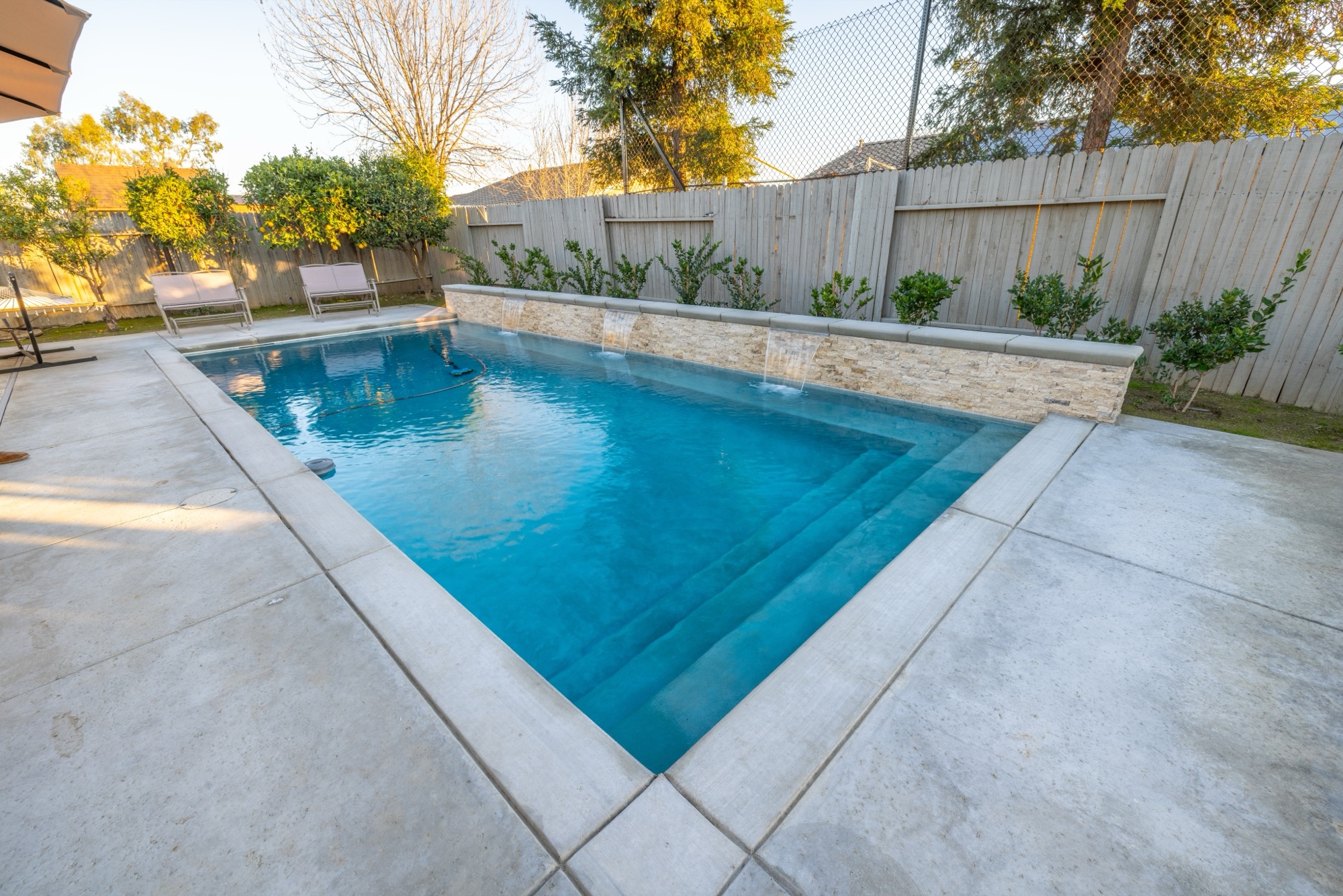 Custom gunite pool with stone wall and spillways — Bakersfield, CA